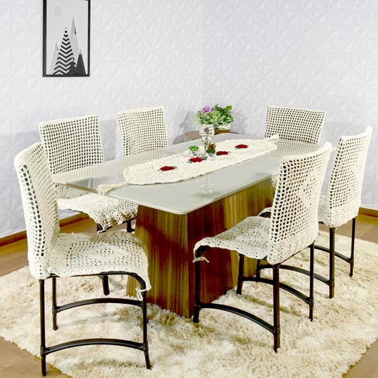 sala de jantar com conjunto de mesa e cadeiras com capa de crochê