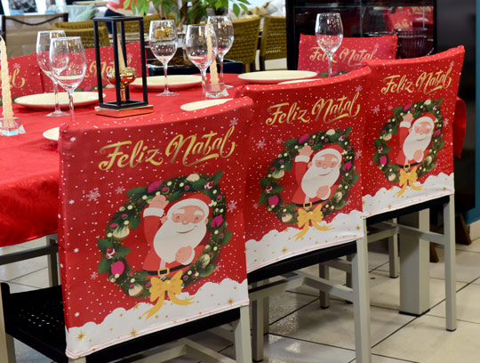 decoração de mesa de natal barata com capas natalinas para encosto de cadeira e toalha de mesa vermelha