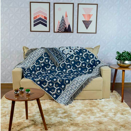 sofá com manta azul de jacquard com estampa geométrica