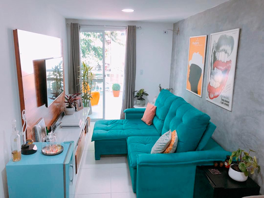 sofá retrátil azul turquesa em sala pequena de apartamento