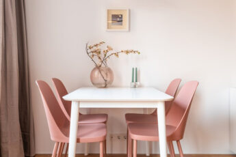 Sala de jantar com modelos de cadeiras rosa
