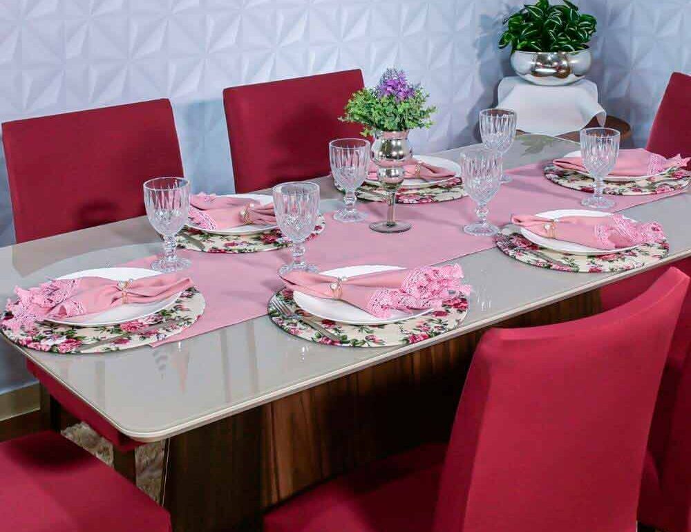 mesa de almoço com sousplats florais, trilho caminho de mesa rosa e guardanapos de tecido rosa rendado