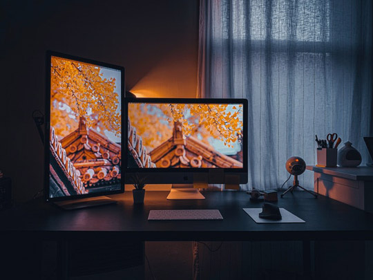 imagem de um computador de mesa com a tela ligada representando o quanto a cortina para quarto que corta luz favorece a visibilidade da imagem