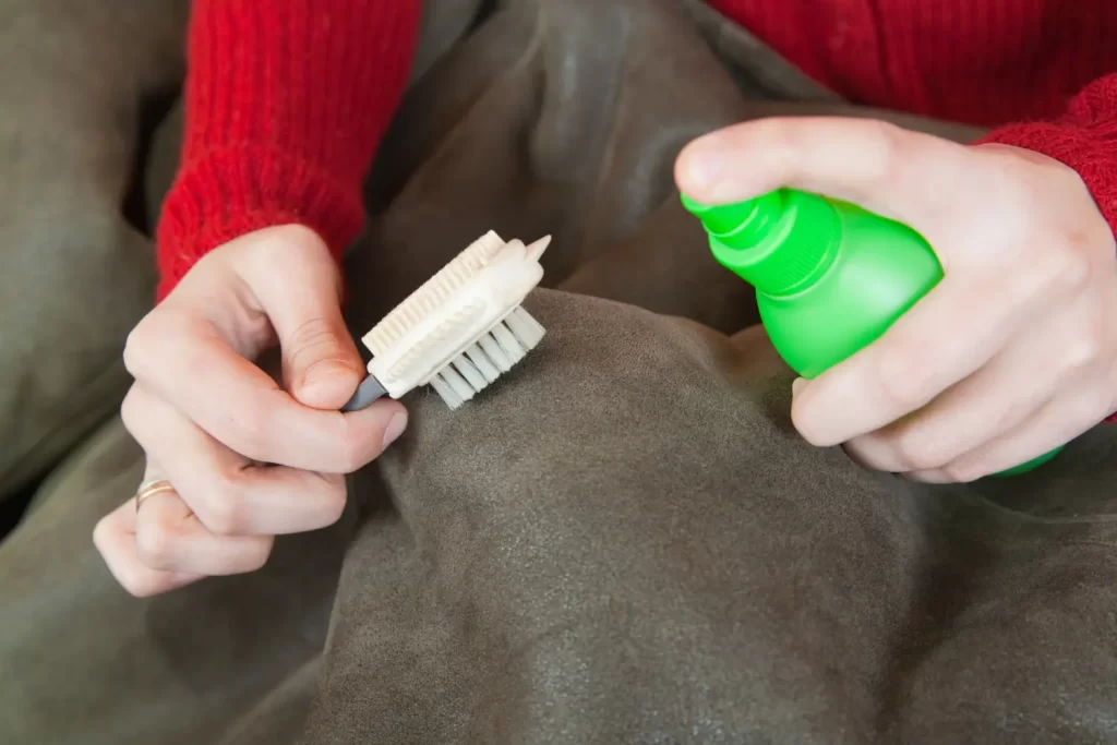 Mulher com produtos de limpeza ensinando a como tirar manchas do sofá