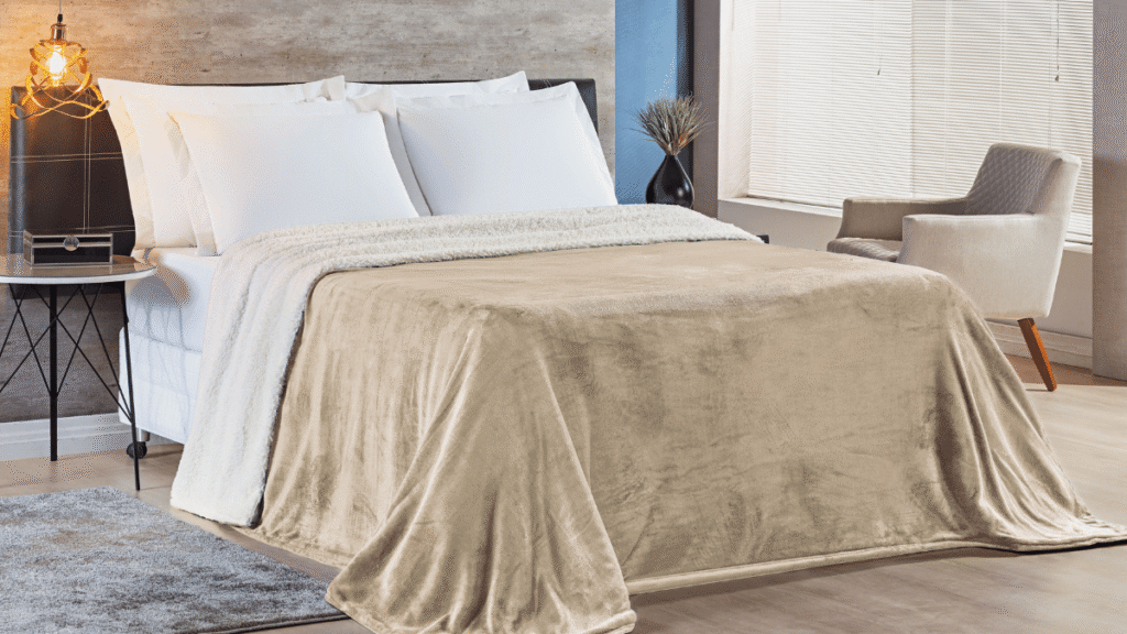 Cobertor Alaska na cor caqui claro com forro de sherpa branco cobrindo cama de casal em ambiente aconchegante.