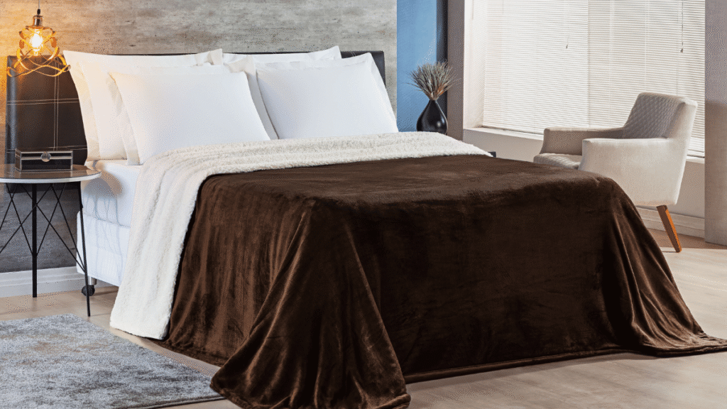 Cobertor Alaska marrom tabaco com forro de sherpa branco drapeado sobre cama em quarto contemporâneo.