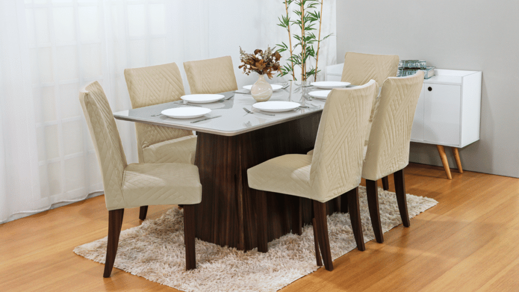 Sala de jantar com cadeiras protegidas por capas acolchoadas bege, que combinam elegância, conforto e proteção contra sujeira.
