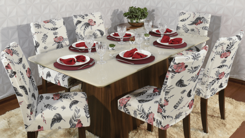 Capa para Cadeira de Jantar Alstromerias – Estampa floral delicada em tons de vermelho e preto, sobre fundo claro, em sala de jantar posta elegantemente.