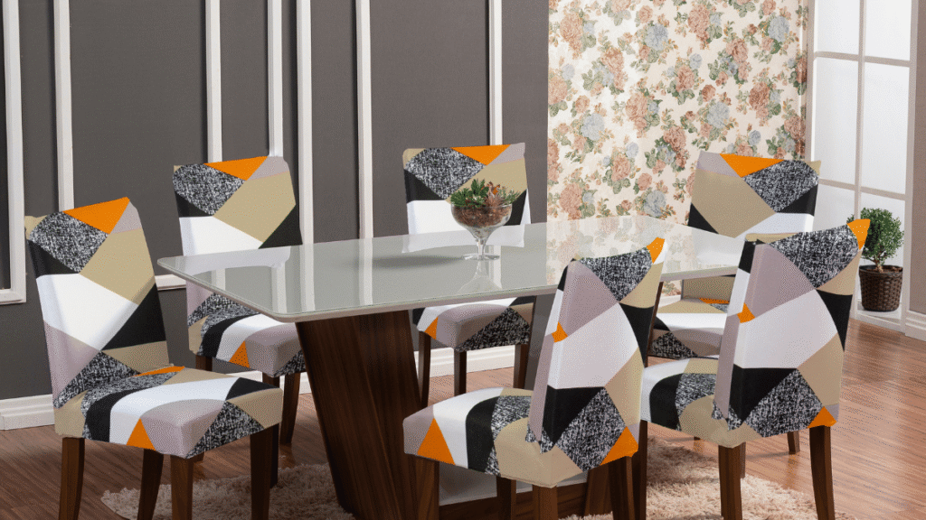 Capa para Cadeira de Jantar Sueter – Estampa geométrica moderna com blocos coloridos em tons de laranja, preto, branco e bege, ideal para uma sala vibrante e cheia de personalidade.